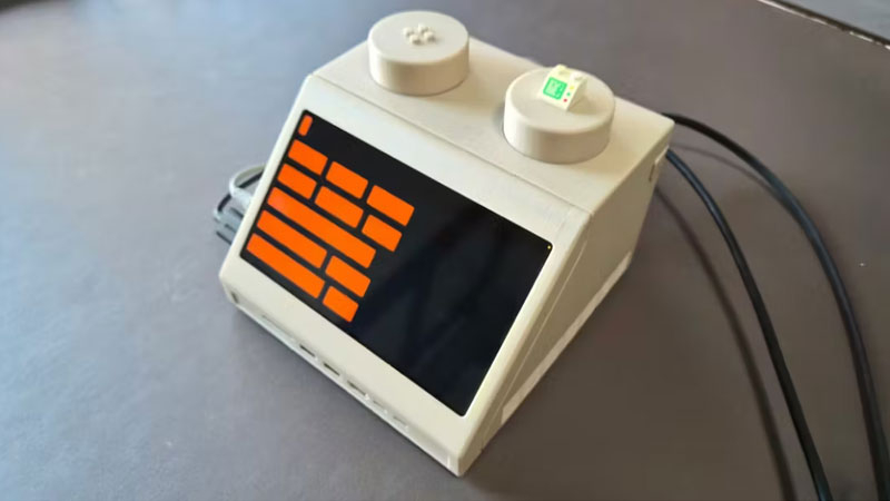 Το Mac mini κρυφά σε έναν εκτενέστερο LEGO‑πλακί, διακοσμημένο σαν τερματικό της δεκαετίας του ’70.